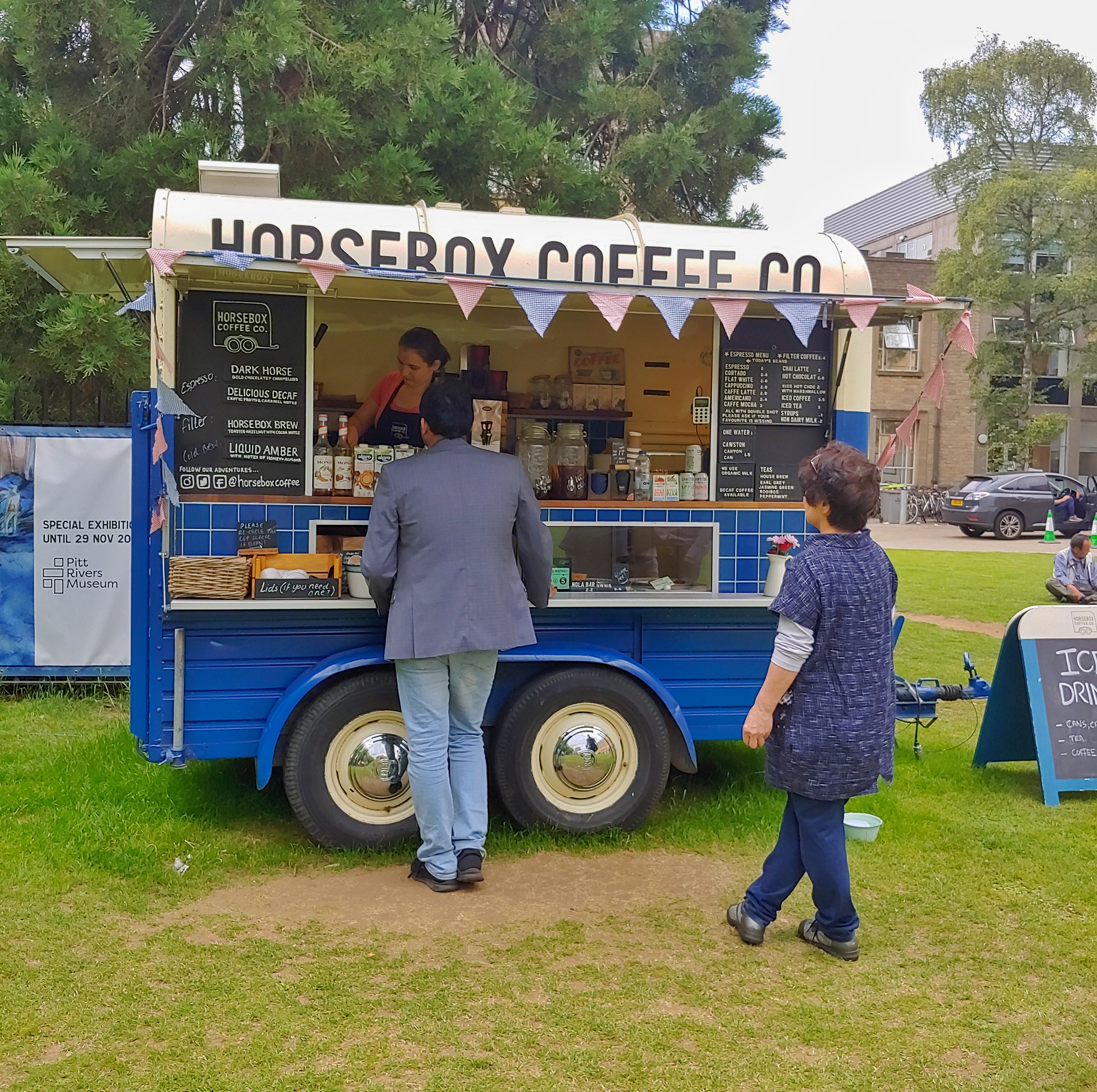 Image of a horsebox converted into a coffee bar, with someone making a coffee inside.