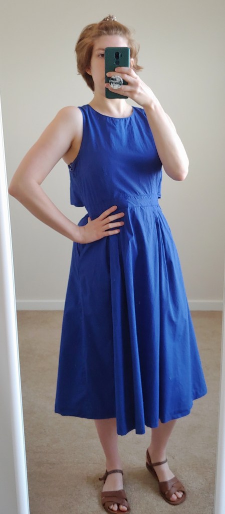 Full length photo of rich blue sleeveless A-line dress.