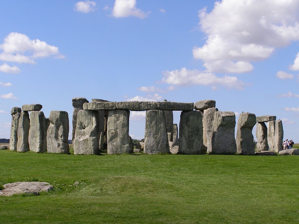 Image of Stonehenge showing the stones on green grass with a blue sky above.