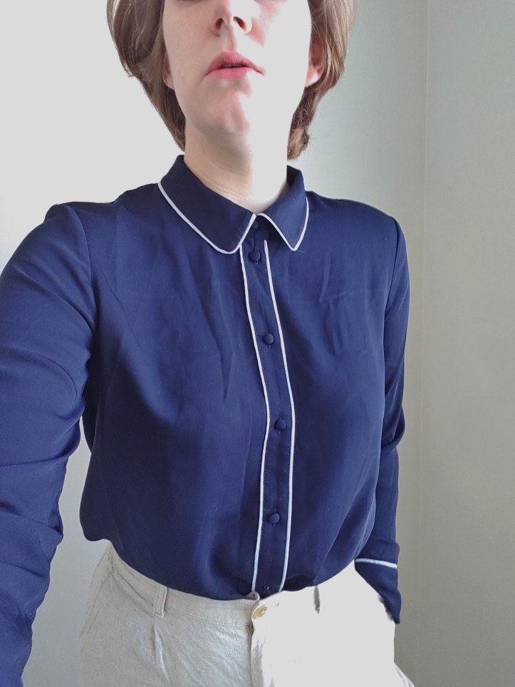 Helen wearing a navy pyjama type top with white piping.