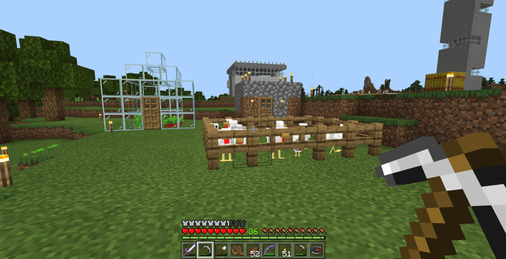 Screenshot of Minecraft showing greenhouse, pen of chicekns, and a stone house and tower in the background.