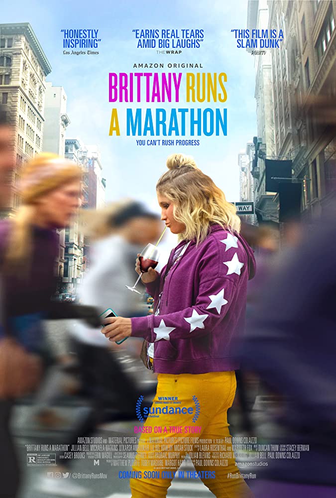 Movie poster for Britanny Runs a Marathon, with Brittany holding her phone and drinking from a wine glass through a straw walking to the left, and blurred people running either side of her to the right of frame.