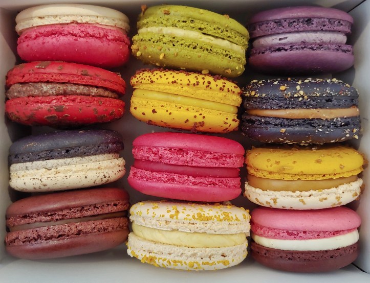 Top down view of a box of brightly coloured maracons.