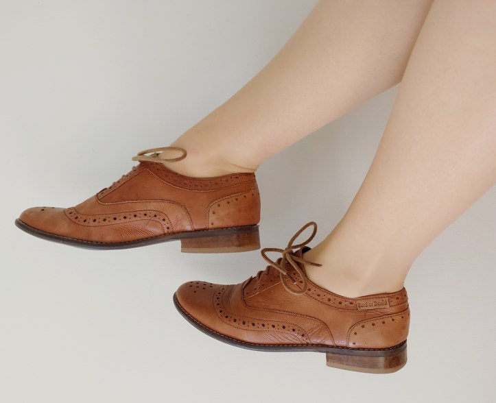 Close-up of Helen wearing soft brown leather brogues.
