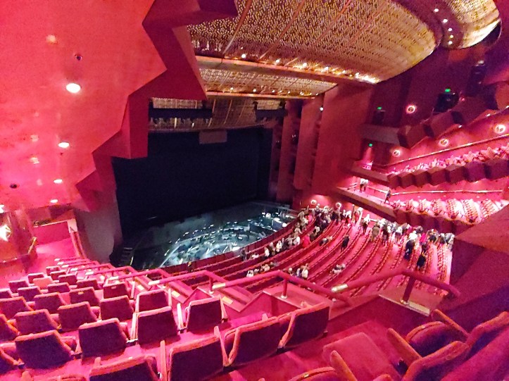View down over the red rows of seats at the State Theatre, Arts Centre Melbourne, towards the orchestra pit and the stage.
