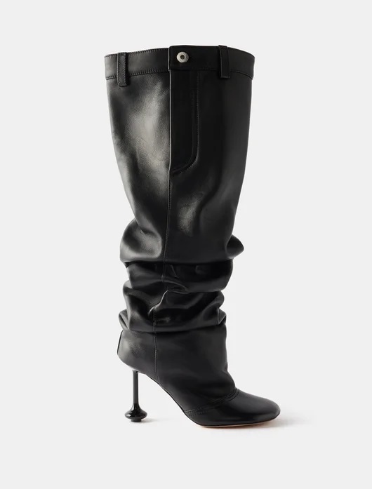 Black over-the-knee boot with rounded toes and think heel with bulbous bottom, and uppers styled to look like a trouser waist.