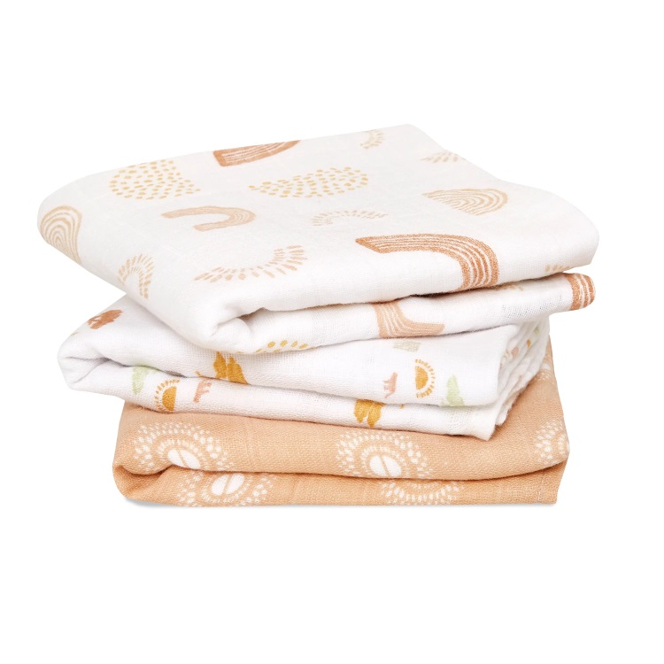 Three colourful orange and cream printed muslin squares neatly piled on top of each other.