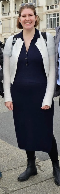 Full length photo of Helen wearing a long navy dress with v-neck and three buttons, with black boots and tights, and her cream coloured Boden cardigan open over the top.